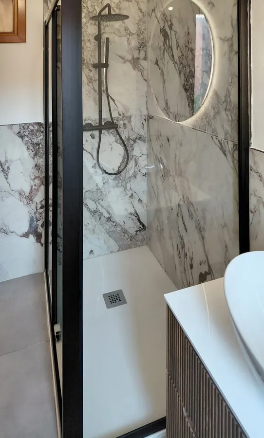 Doccia con rivestimento effetto marmo e soffione a pioggia